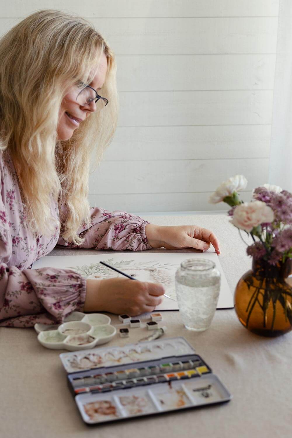 Karolina Brunström målar med akvarell vid arbetsbord