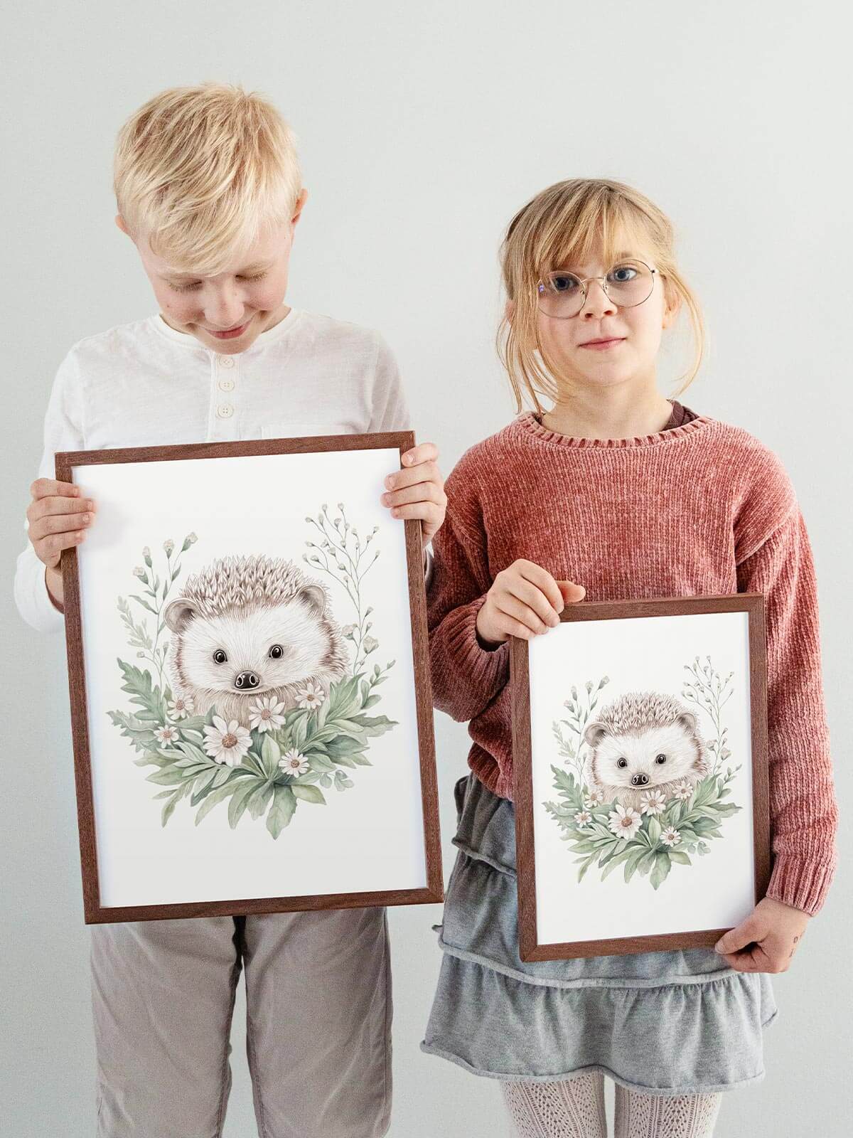 Barn håller handmålad poster med igelkotten Nilo i mörkbrun ekram